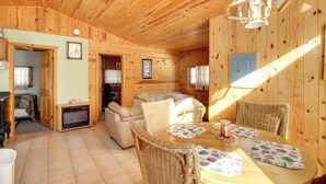A cozy wooden cabin interior with a dining area, a sofa, and a fireplace. - Boat Dock & Fire Pit: Waterfront Home in Crosslake (Crosslake)