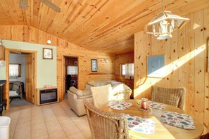 A cozy wooden cabin interior with a dining area, a sofa, and a fireplace. - Boat Dock & Fire Pit: Waterfront Home in Crosslake (Crosslake)