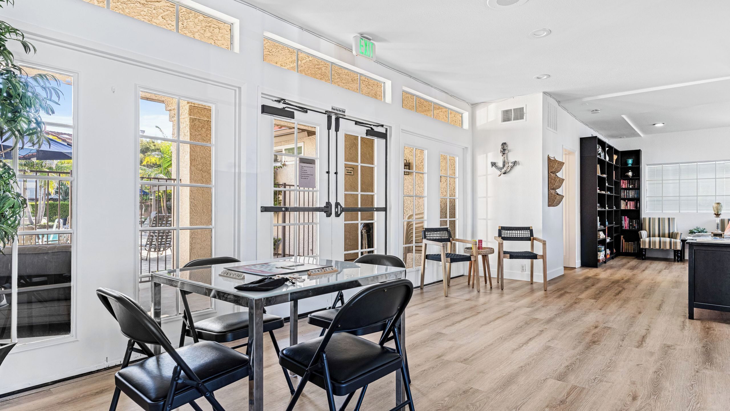Un intérieur moderne comprenant un coin repas, une bibliothèque et une vue dégagée grâce à de grandes fenêtres.