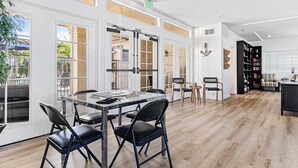 Un'ampia stanza con un grande tavolo da pranzo, sedie e una libreria.
