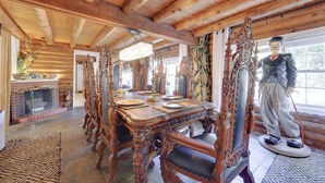 A rustic wooden dining room with a large table, ornate chairs, and a statue. - < 4 Mi to Boat Ramp & Mickler Beach: Unique Cabin (Ponte Vedra Beach)