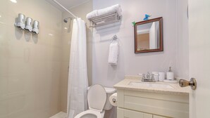 Une salle de bain équipée d’une douche, de toilettes, d’un lavabo et d’un porte-serviettes.
