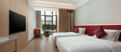 Habitación de hotel con dos camas, televisión y vista al exterior.