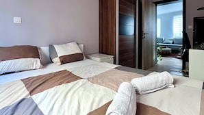 Una habitación de hotel moderna con una cama grande, un armario y vistas al exterior.