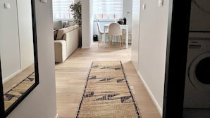 Un pasillo que conduce a un comedor con un sofá y una mesa.
