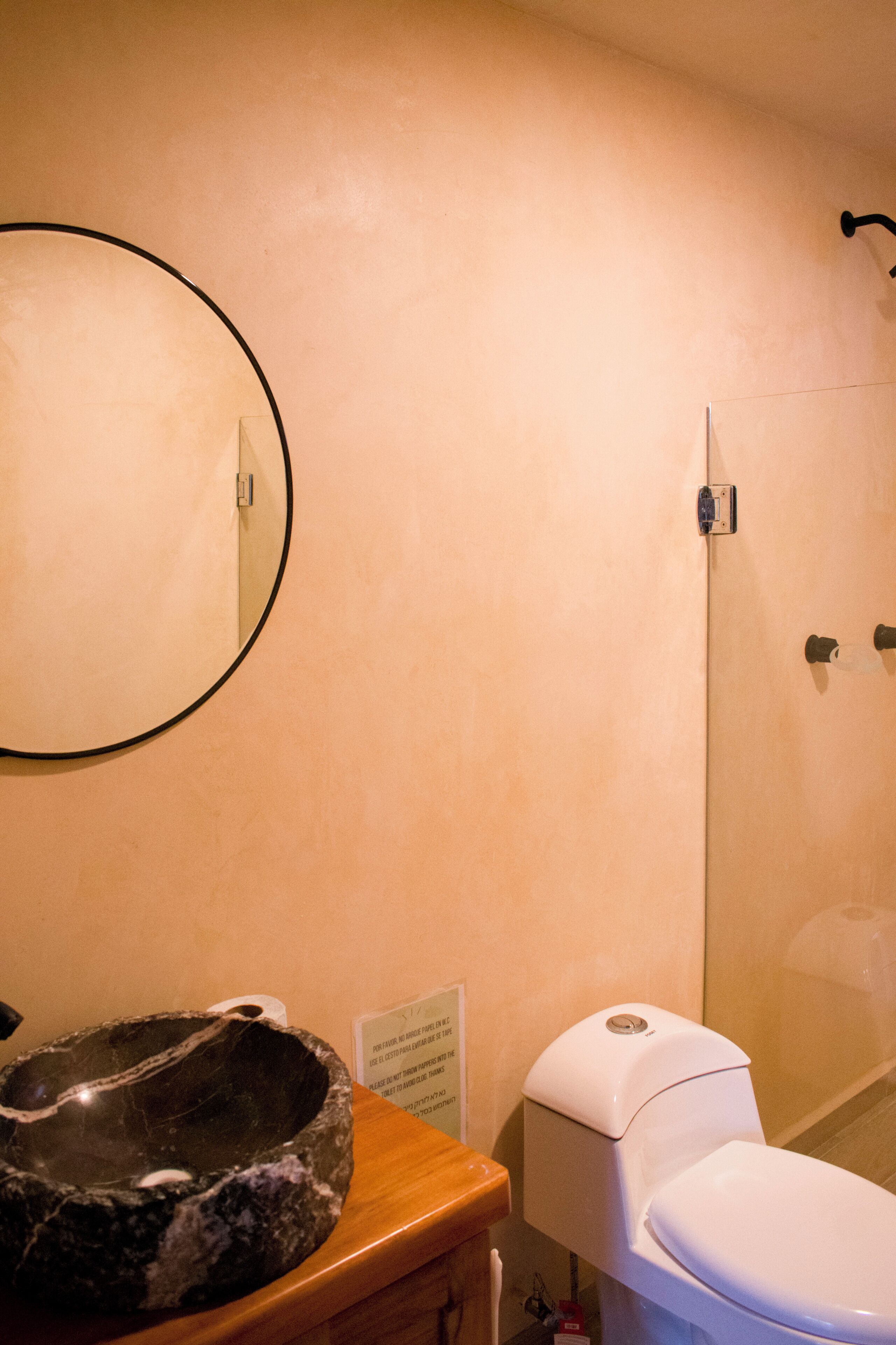 Ein Badezimmer mit Toilette, Waschbecken und Duschbereich.
