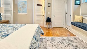 Une chambre à coucher comprenant un lit, un bureau, une chaise, une fenêtre avec des stores et une étagère fixée au mur.