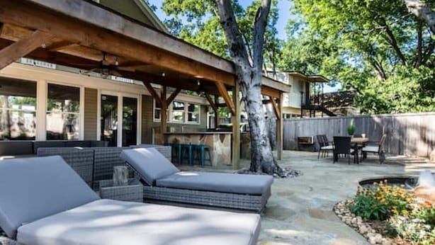 Un espace extérieur aménagé, abrité et doté de meubles en osier et d’un patio en pierre.