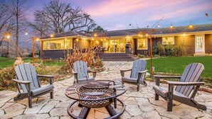 A modern house with a patio area featuring a fire pit and Adirondack chairs. - The Only Private Pickleball Vacation in Dallas! (Dallas)