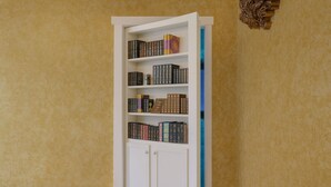 A bookshelf with multiple shelves filled with books, set against a yellow wall.