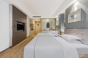 A modern hotel room with a large bed, a TV, a minibar, and a bathroom visible through an open door. - Anqing Mingjia Hotel (Anqing)