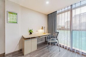 A modern office space with a desk, chair, and a large window with curtains. - Anqing Mingjia Hotel (Anqing)