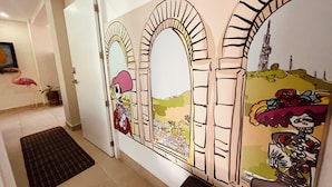 A hallway with a mural featuring arches and a cityscape. - Charming, fully appointed 1-bedroom apartment in PV’s amazing Zona Romantica (Puerto Vallarta)