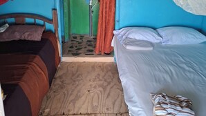 A small, compact room with two beds, a single sink, and a mirror. - Graces Place Cool Spot  (Corn Islands)