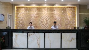 Un mostrador de recepción con paneles de mármol y una pared decorativa.