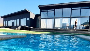 Une piscine avec un bâtiment moderne en arrière-plan.