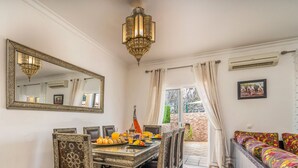 A dining area with a table set for breakfast, a large ornate mirror, and a chandelier. - #298 Villas Luz H by Home Holidays (Albufeira)