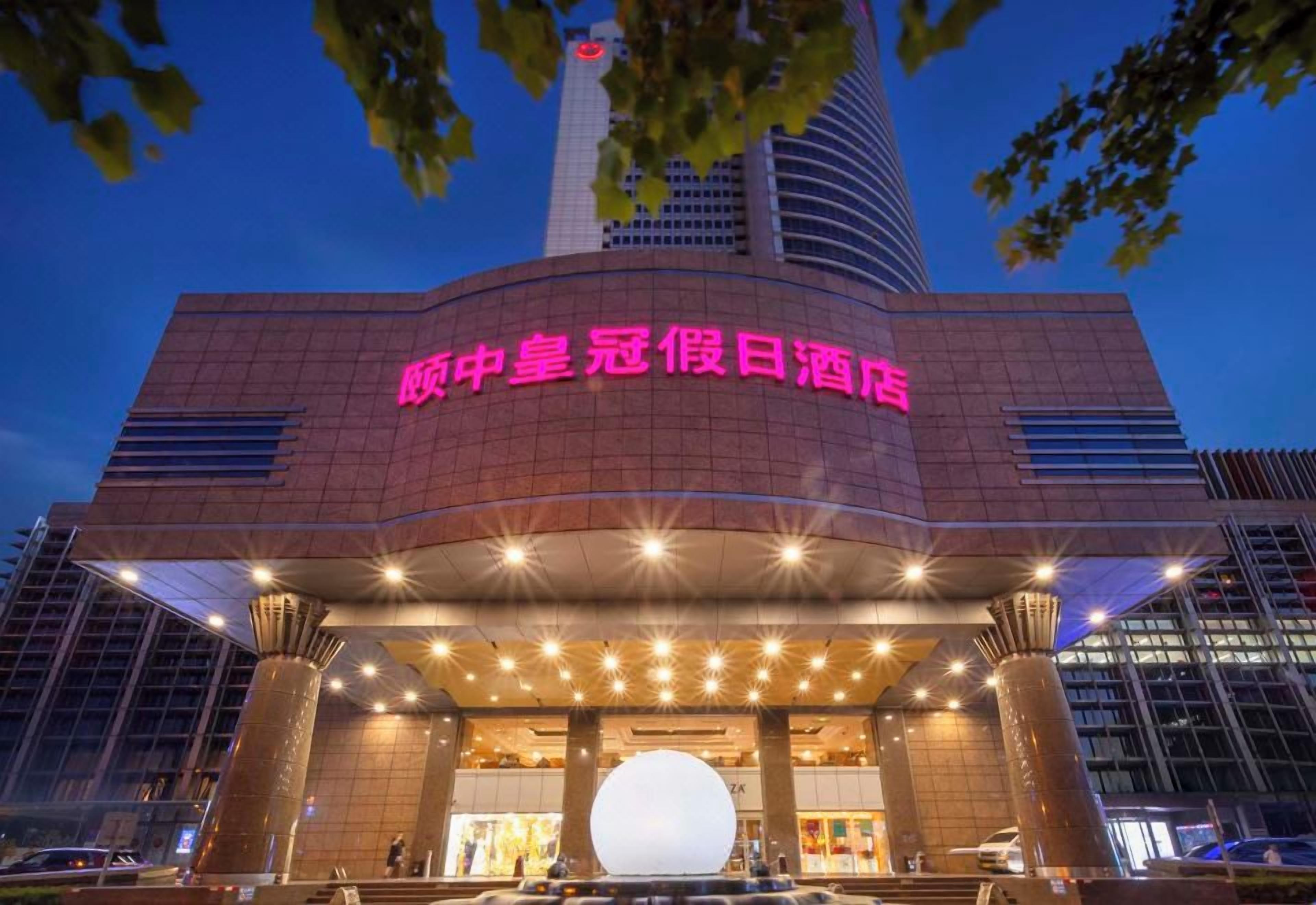 A hotel entrance with a prominent sign, a large spherical light feature, and a modern architectural design.