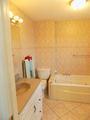 A bathroom with a sink, toilet, bathtub, and a mirror.