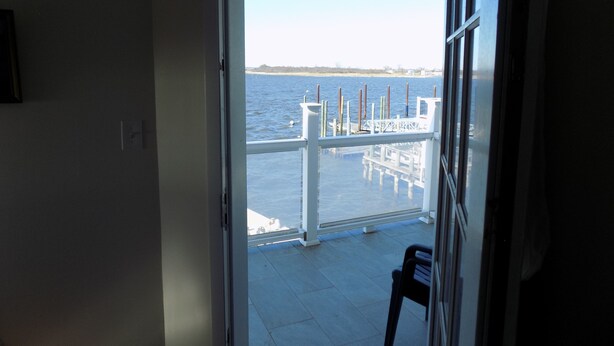 Blick vom Balkon, blauer Himmel und Wasser im Hintergrund.