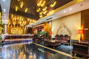 A lobby with a reception desk, seating area, and a decorative wall. - Yitel (Chengdu)