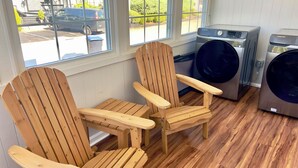 A laundry room with two wooden chairs, a washing machine, and a dryer. - Cozy 2-bedroom, 1-bathroom condo,  two short blocks from the beach! (Old Orchard Beach)