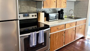 Une cuisine avec des meubles en bois, un réfrigérateur en acier inoxydable, un four à micro-ondes et une cuisinière.