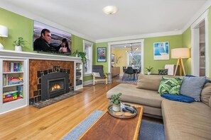 TV connectée, cheminée, livres, chaîne hi-fi