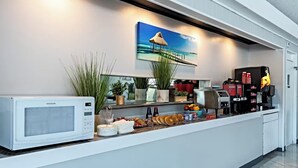 A modern kitchen with a built-in microwave, a coffee machine, and a variety of food items on the counter. - Palm Tree Inn Altamonte Springs Orlando (Altamonte Springs)