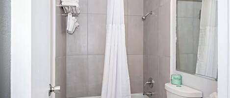 A bathroom with a bathtub, a shower, a toilet, and a sink.