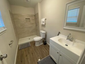 Un baño con ducha, inodoro y lavabo.