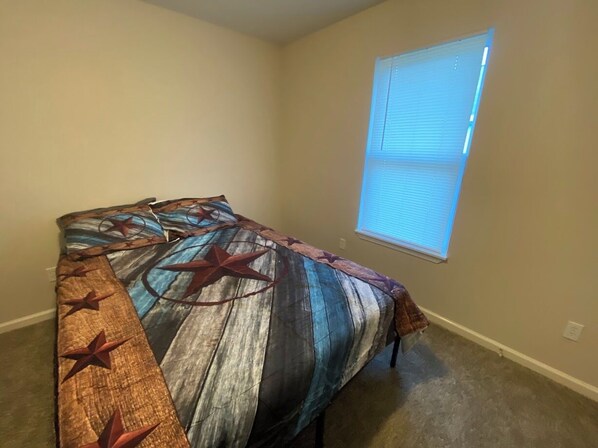 Un dormitorio con cama, ventana y piso alfombrado.
