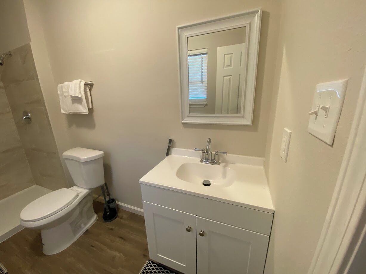 A bathroom with a toilet, sink, and shower.