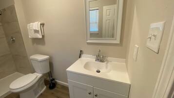 A bathroom with a toilet, sink, and shower.