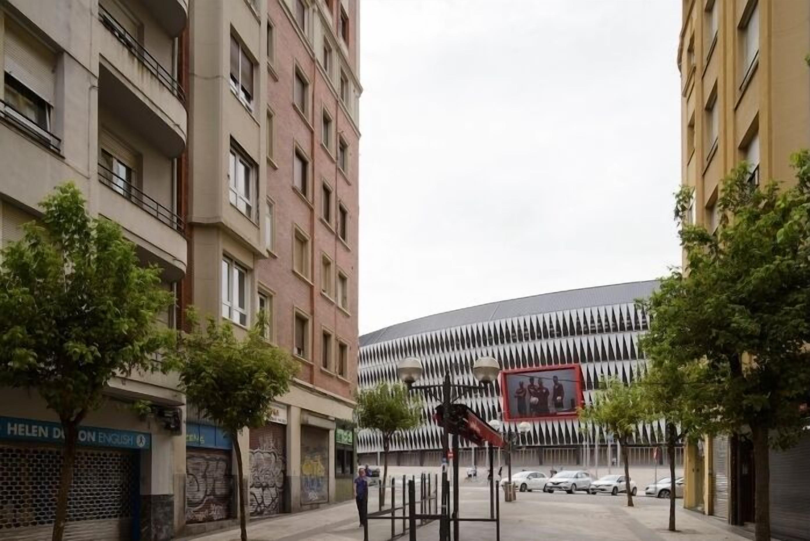 A street view with a modern building featuring a unique facade and a large mural.