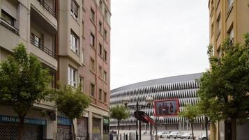 A street view with a modern building featuring a unique facade and a large mural.