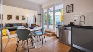 Een moderne keuken met een vaatwasser en een eethoek met een tafel en stoelen.