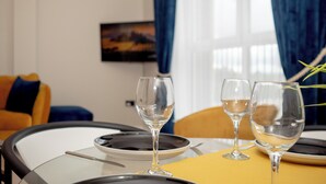 A dining table with three wine glasses, plates, and cutlery.