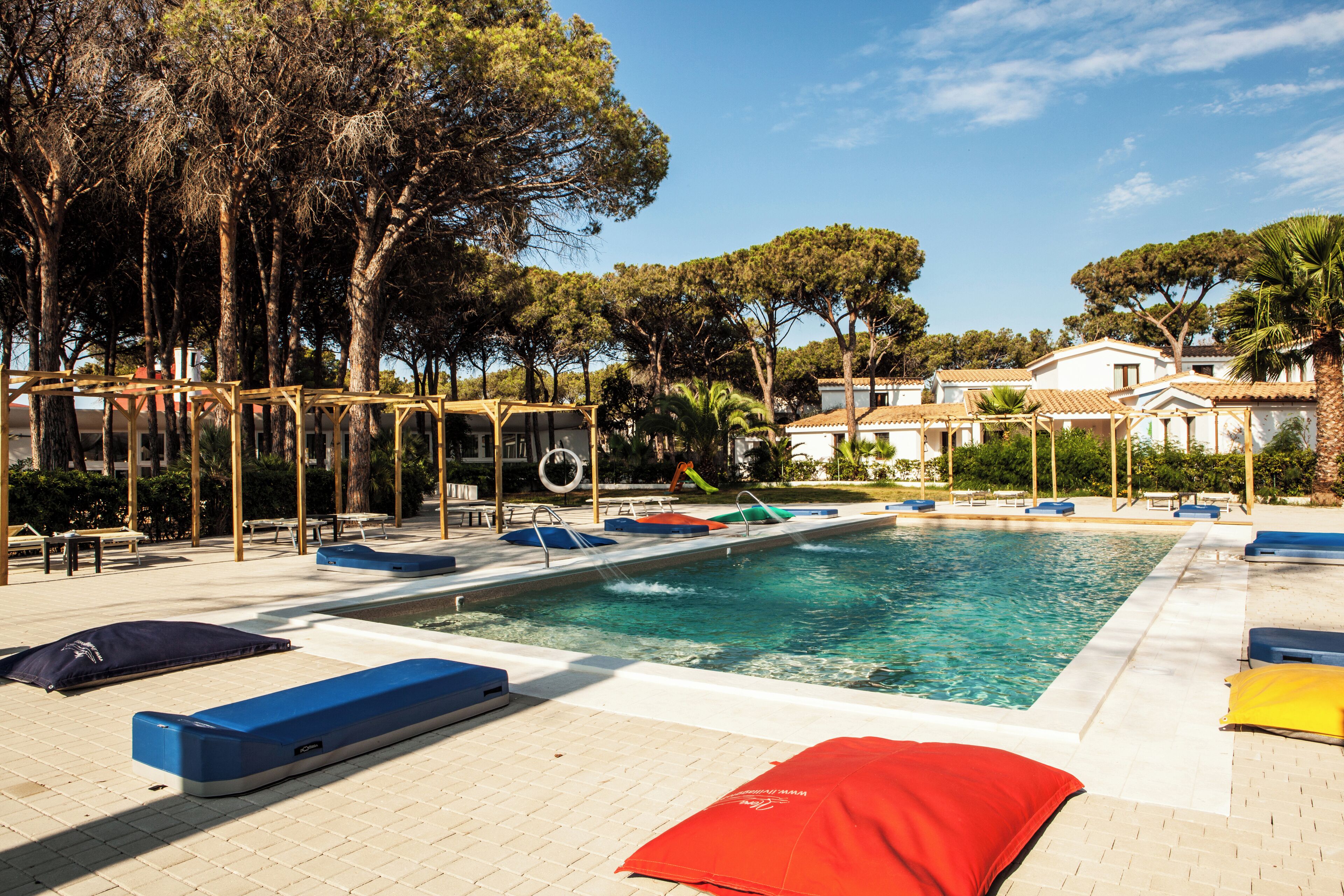 A swimming pool with lounge chairs and a pergola structure.
