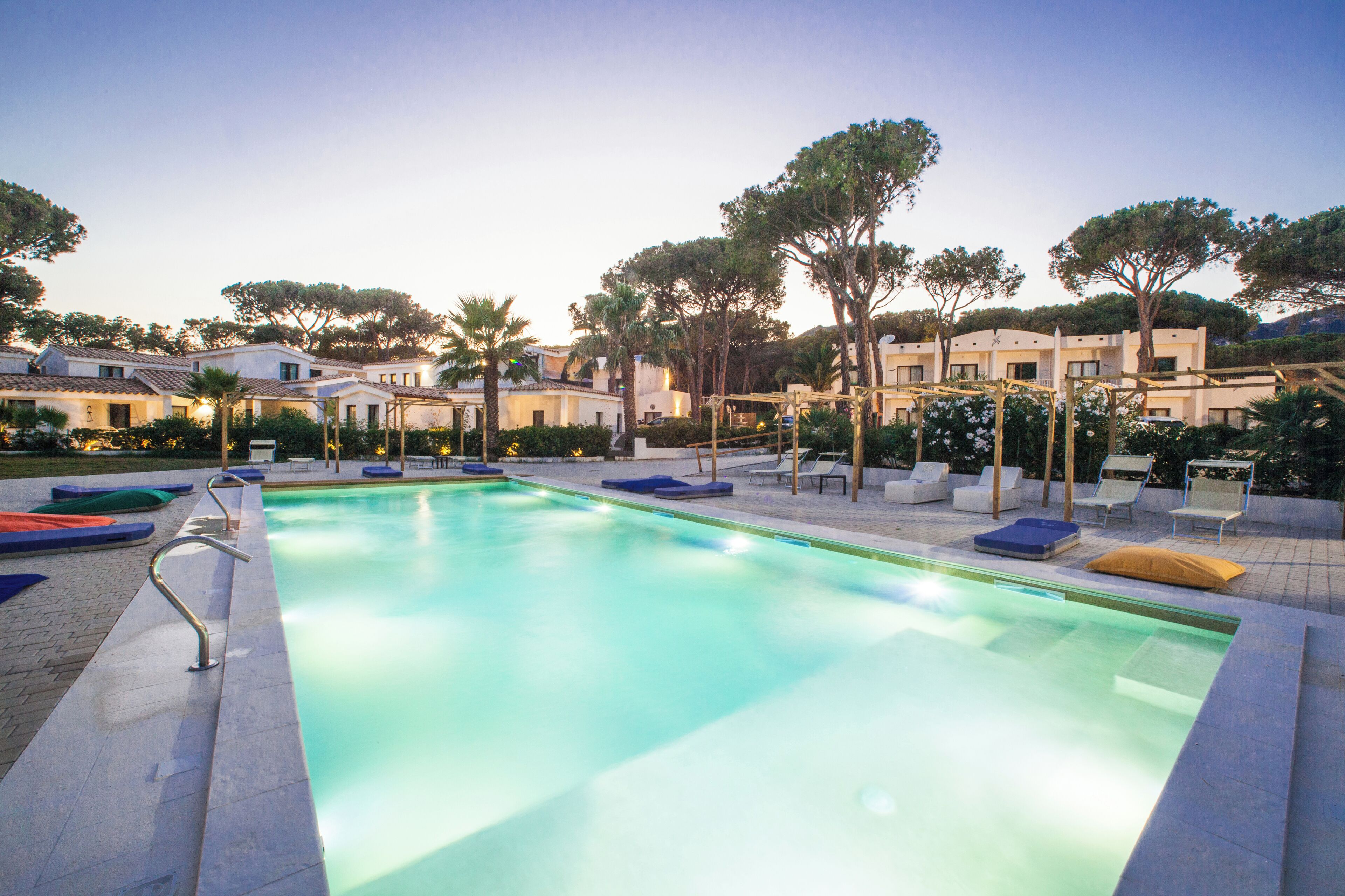 A swimming pool with lounge chairs and a pergola.
