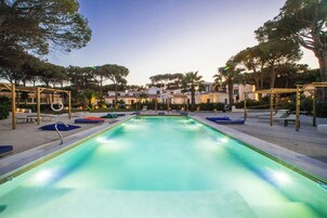 Una piscina al aire libre de temporada, sombrillas