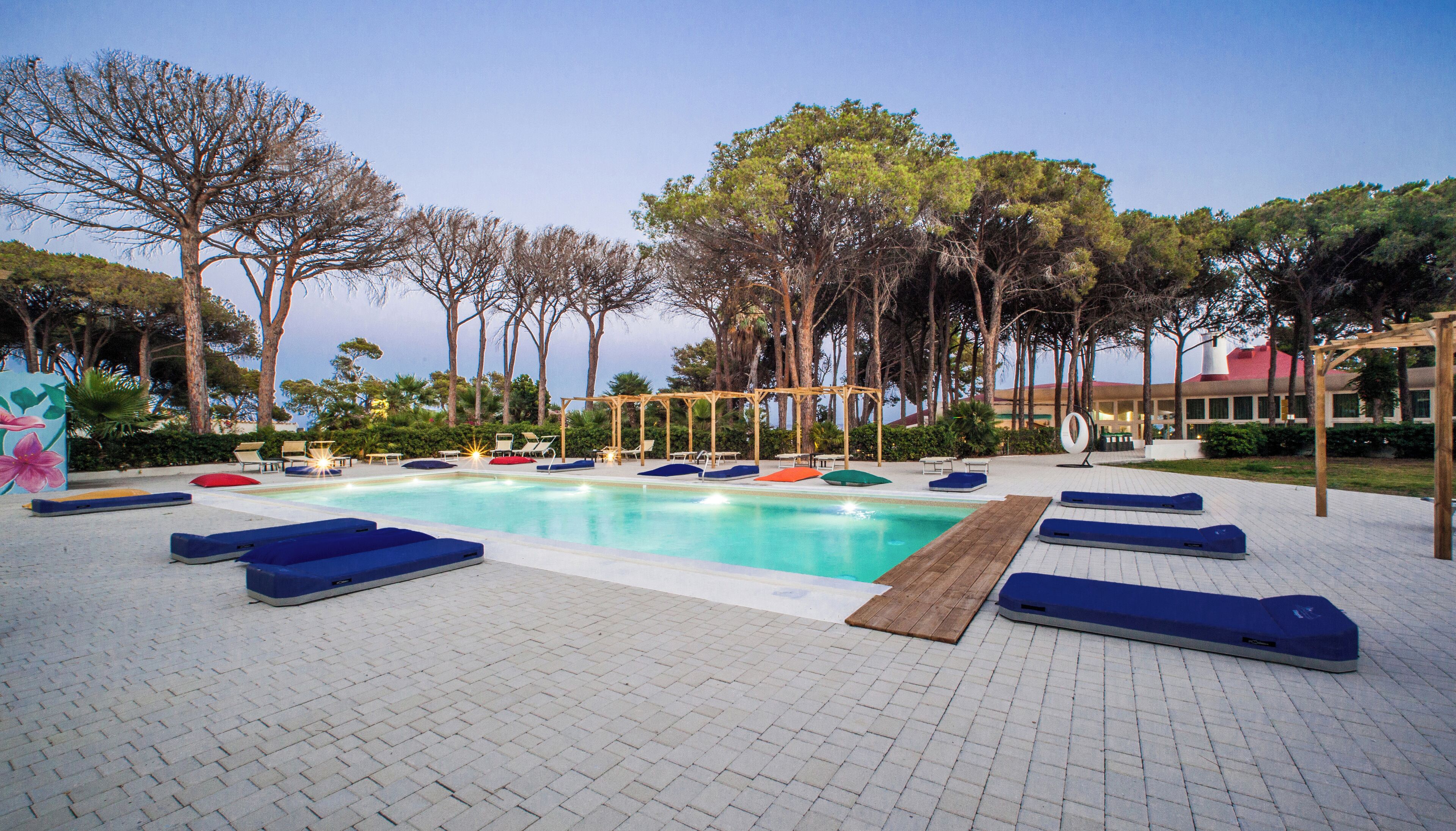 Ein Poolbereich mit Liegestühlen und einer Pergola.