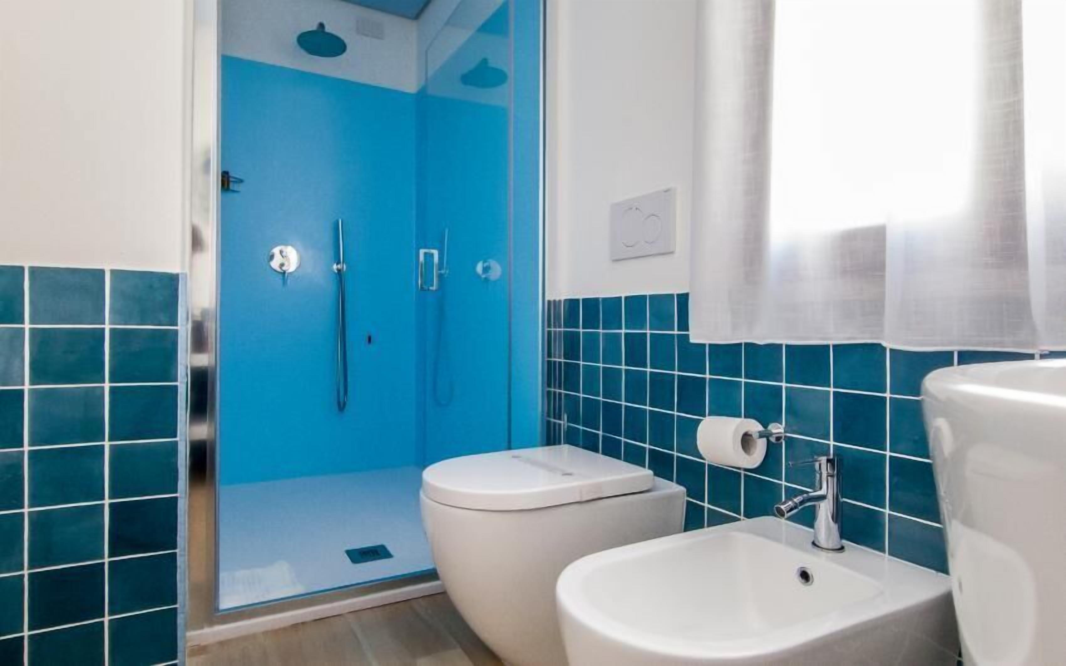 Un baño con ducha, inodoro y lavamanos.