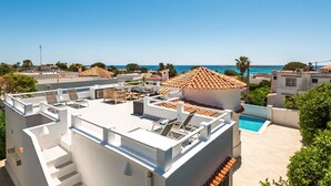 A rooftop terrace with outdoor seating, a swimming pool, and a view of the sea. - Villa Fontana, little paradise (Punta Prima)