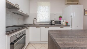 A modern kitchen with white cabinets, a stainless steel range hood, a built-in oven, a microwave, and a refrigerator. - 1 bedroom awesome apartment in Biograd na Moru (Biograd na Moru)