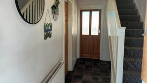 A staircase with a patterned carpet, a wooden door with frosted glass panels, and a mirror on the wall. - Charming 3-bed House in Birmingham Near nec & hs2 (Birmingham)