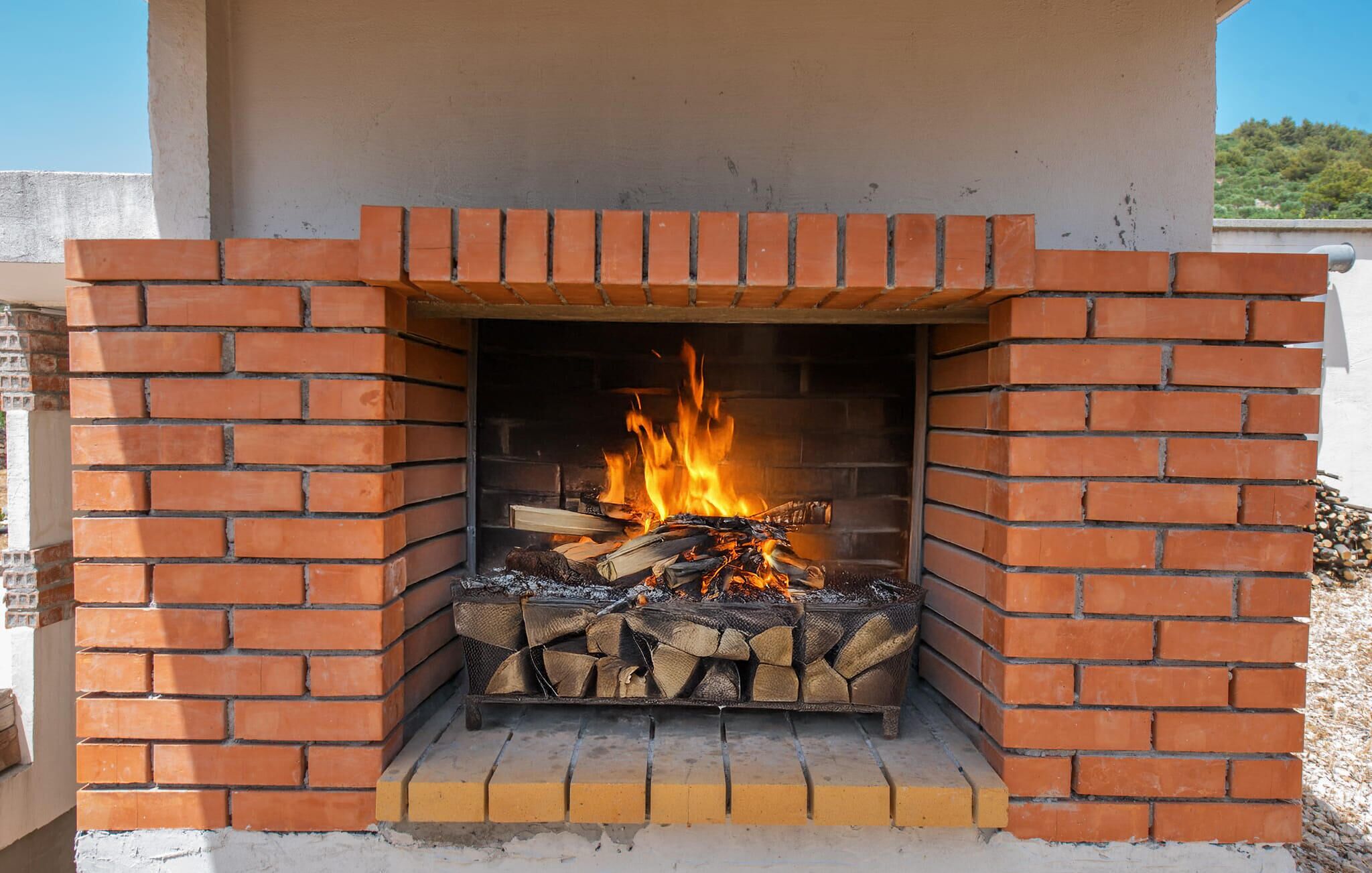 Una chimenea de ladrillo con fuego encendido.