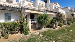 A white building with a balcony, a small garden, and a clear blue sky. - Anacasa Duplex Marineta Bot DUP2136 (Denia)