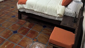 Un dormitorio con cama, sofá, televisor y aire acondicionado.