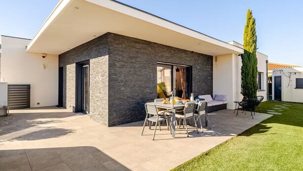 A modern house with a patio, a dining area with outdoor furniture, and a well-maintained lawn. - Villa "Dolce Vida" golf / lake / spa 6p (Villeneuve-de-la-Raho)